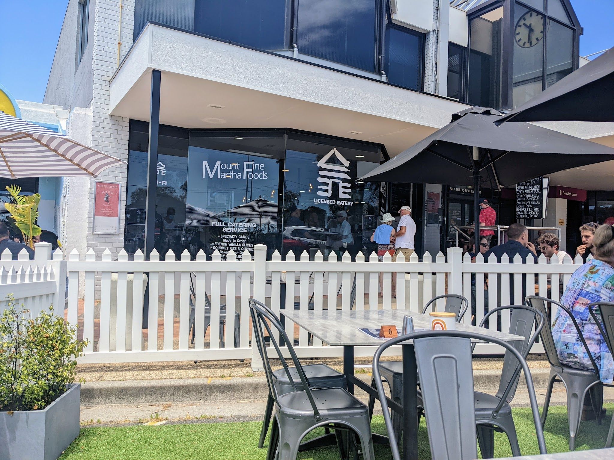 Mount Martha Fine Foods exterior with outdoor seating, white picket fence and shop signage